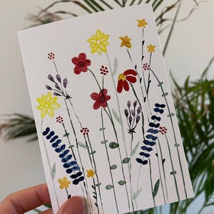 Handgemalte Aquarellkarte mit Blumenfeld