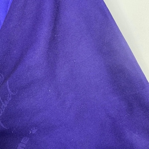 Puede incluir: Primer plano de una secci&oacute;n de tela morada oscura. La tela tiene una textura sutil y parece ser de color liso. La imagen est&aacute; bien iluminada, destacando la textura y el color del material.