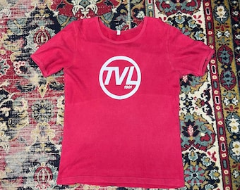 Camiseta vintage TVL de 1980 con estampado gráfico, color rojo, número 3, estilo deportivo retro.