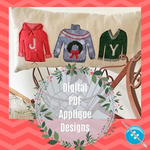 May include: A white pillow with three embroidered sweaters that spell out "JOY". The sweaters are red, blue, and green. The pillow is sitting on a wooden surface with a wreath of green leaves around it. The text "Digital PDF Applique Designs" is written in white on a pink background.