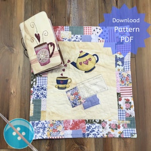 Könnte beinhalten: Ein gesteppter Tee-Cozy mit Patchwork-Design, das eine Teekanne und eine Teetasse mit Herzen zeigt. Der Cozy ist von einem blauen und weißen Rand umgeben. Das Bild zeigt auch eine separate gesteppte Buchhülle mit einem ähnlichen Design.