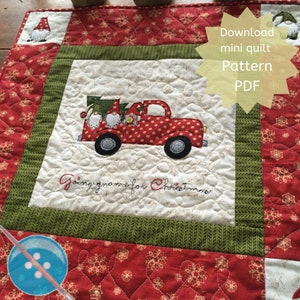 May include: A red and white truck with a Christmas tree and gnomes on the back. The truck is on a white background with the words "Going home for Christmas" embroidered in red. The image is surrounded by a green and red border with a snowflake pattern.