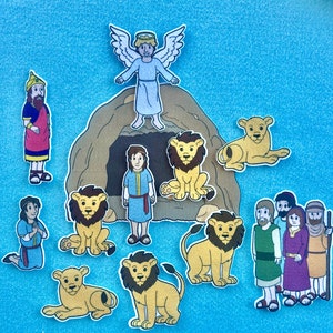 May include: A colorful felt illustration depicting a scene from the Bible story of Daniel in the lion's den. The illustration features a cave with a lion inside, a man standing outside the cave, and an angel above the cave. The illustration is perfect for teaching children about the Bible.