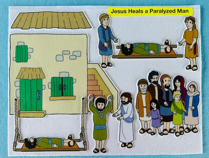 May include: A felt illustration depicting Jesus healing a paralyzed man. The man is lying on a stretcher, surrounded by people. Jesus is standing in front of the man, with his hands raised in prayer. The illustration is set against a backdrop of a house with a green door.