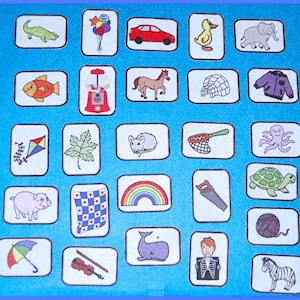 May include: A colorful game board with 25 squares, each containing a different image. The images include a kite, a fish, a horse, a turtle, a rainbow, a saw, a pig, a whale, a violin, a zebra, a duck, an elephant, a car, a balloon, a gumball machine, a leaf, a mouse, a net, an octopus, a checkered flag, a yarn ball, a jacket, an igloo, an umbrella, and a man with an x-ray.