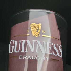 May include: A clear glass pint glass with a gold Guinness logo and the text "1759" and "Draught".