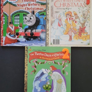K&ouml;nnte beinhalten: Drei Vintage-Kinderb&uuml;cher. Das Buch oben links ist "Thomas' Night Before Christmas" mit Thomas der Lokomotive. Das Buch oben rechts ist "The Twelve Days of Christmas". Das untere Buch ist ebenfalls "The Twelve Days of Christmas".