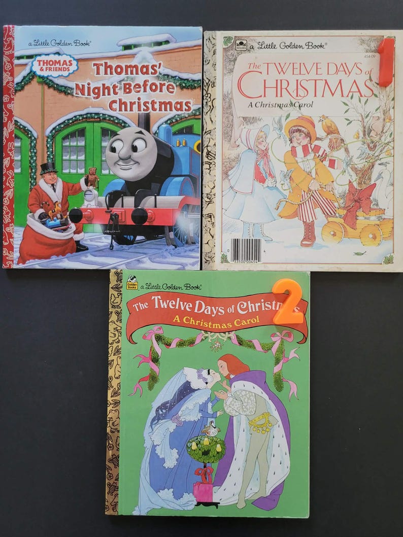 K&ouml;nnte beinhalten: Drei Vintage-Kinderb&uuml;cher. Das Buch oben links ist "Thomas' Night Before Christmas" mit Thomas der Lokomotive. Das Buch oben rechts ist "The Twelve Days of Christmas". Das untere Buch ist ebenfalls "The Twelve Days of Christmas".