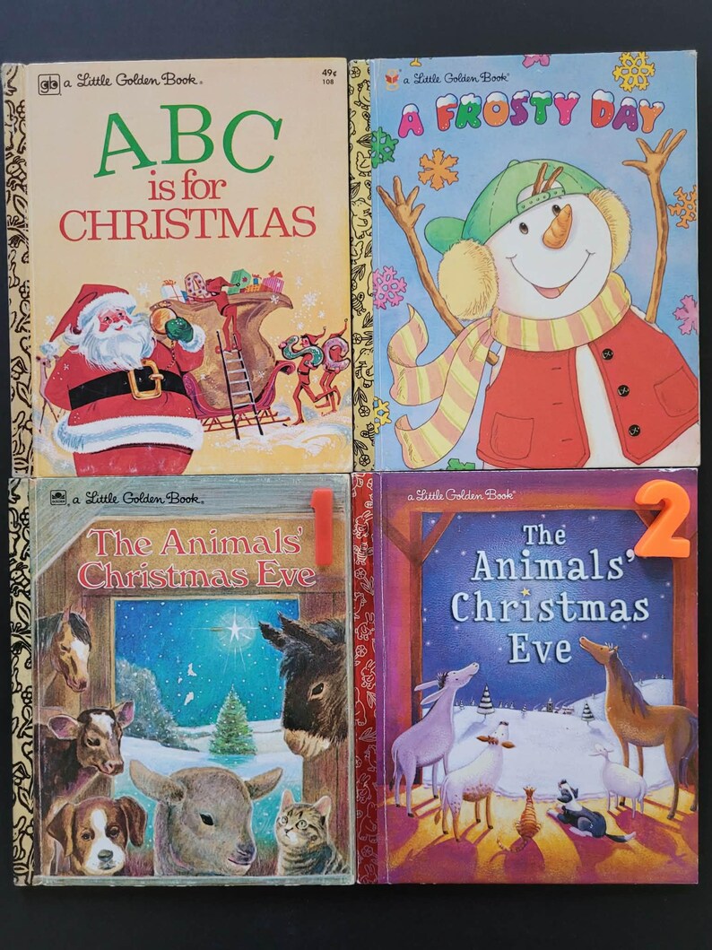 K&ouml;nnte beinhalten: Vier Vintage-Kinderb&uuml;cher mit farbenfrohen Illustrationen. Zu den Titeln geh&ouml;ren "ABC is for Christmas", "A Frosty Day" und zwei Ausgaben von "The Animals' Christmas Eve". Die B&uuml;cher zeigen Bilder von Santa Claus, einem Schneemann und verschiedenen Hoftieren.