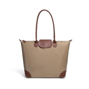 May include: A beige tote bag with brown leather accents. The bag features a brown leather flap closure, handles, and corner patches. The bag is designed with a rectangular shape and a zipper closure.