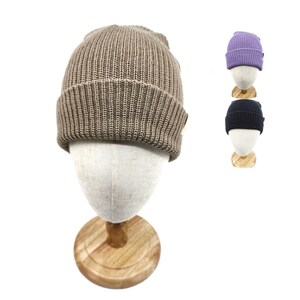 May include: A brown knitted beanie with a ribbed texture. The beanie is displayed on a wooden mannequin head.