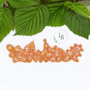 Może przedstawiać: Pomarańczowa i złota aplikacja koronkowa z kwiatowym wzorem, na białym tle. Aplikacja jest misternie zdobiona delikatnym, ażurowym wzorem. Zielone liście są widoczne w tle. Tekst "Lacy Botanics" znajduje się w tle.