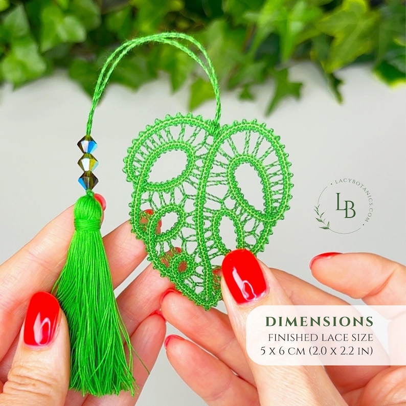 May include: A bright green lace monstera leaf ornament featuring a matching tassel and three iridescent beads on a string. The finished lace size is 5 x 6 cm (2.0 x 2.2 in). A circular logo with the text LACYBOTANICS.COM is visible on the right.