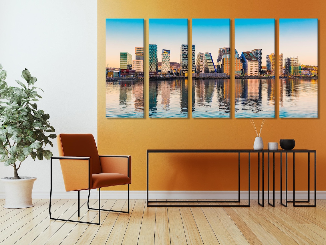 Room mockup showing a framed modern city skyline artwork above a desk and chairs
