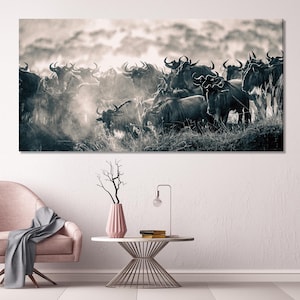 Może przedstawiać: Czarno-biała fotografia stada gnu na trawiastym polu. Zwierzęta są gęsto upakowane, a ich rogi i ciała tworzą wzorzystą fakturę. Obraz ma odcień sepii, z zamgloną atmosferą.