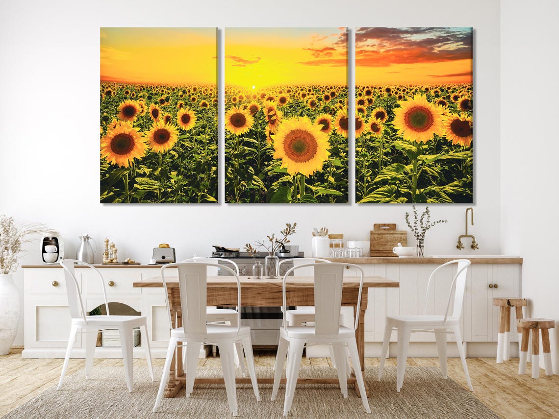 Sunflower field at sunset with bright yellow flowers and warm orange clouds detail view