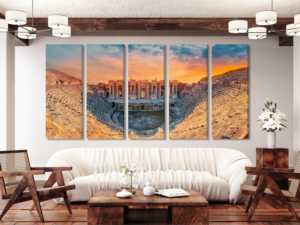 Room mockup showing three-panel amphitheatre sunset artwork above a dining table and chairs