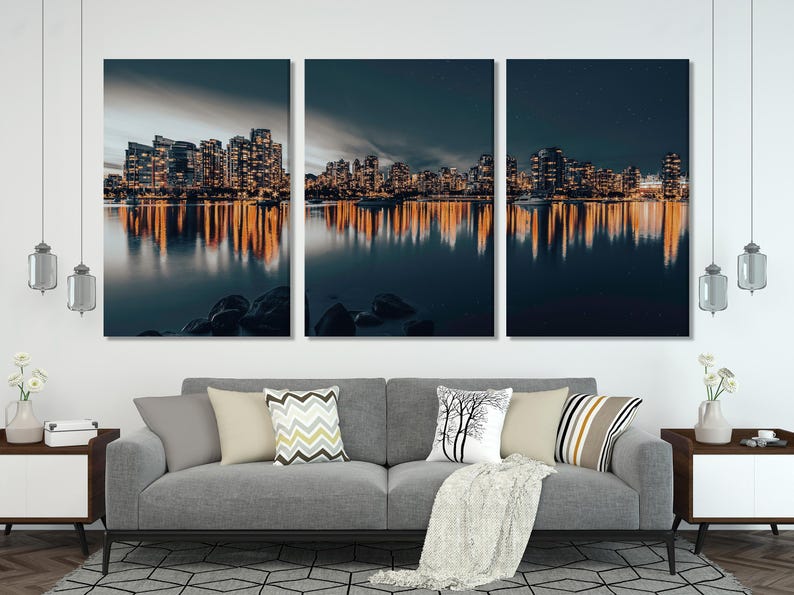 Night city skyline with warm building lights reflected on calm dark water