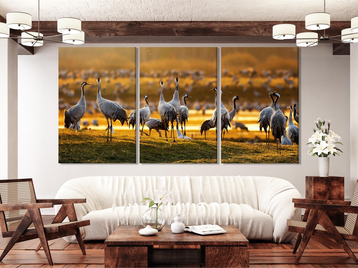 Living room mockup with a sofa and two chairs, with a five-panel crane bird wall artwork above