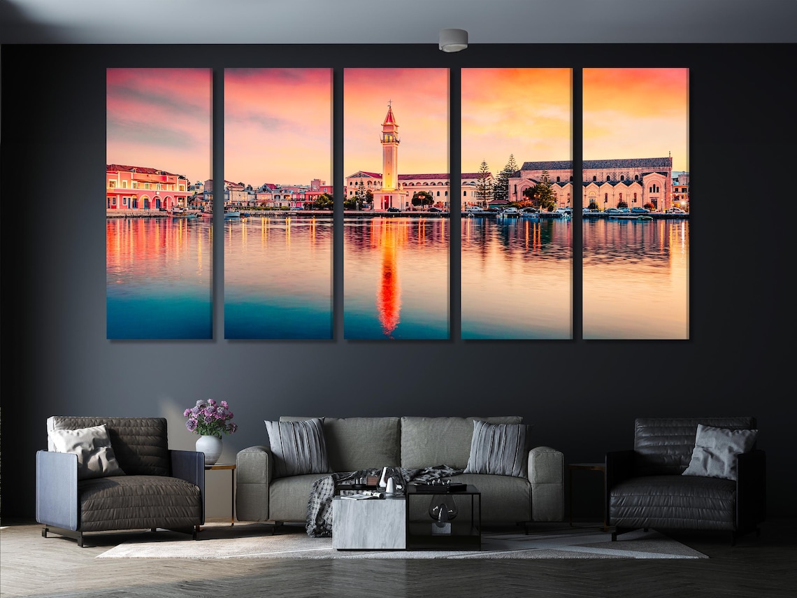 Sunset coastal town with a church tower and mirrored reflections on calm water detail view