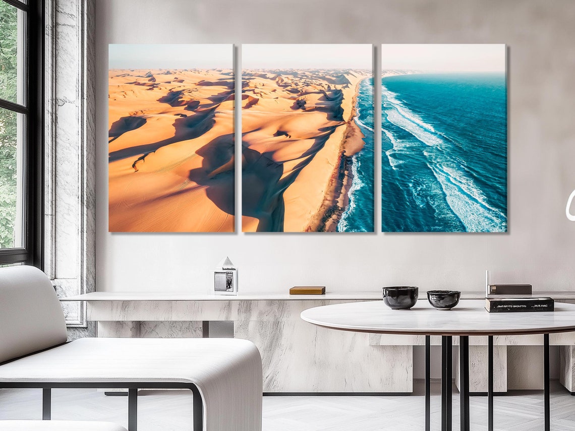 Aerial view of golden desert dunes meeting bright blue ocean waves along a curving shoreline detail view