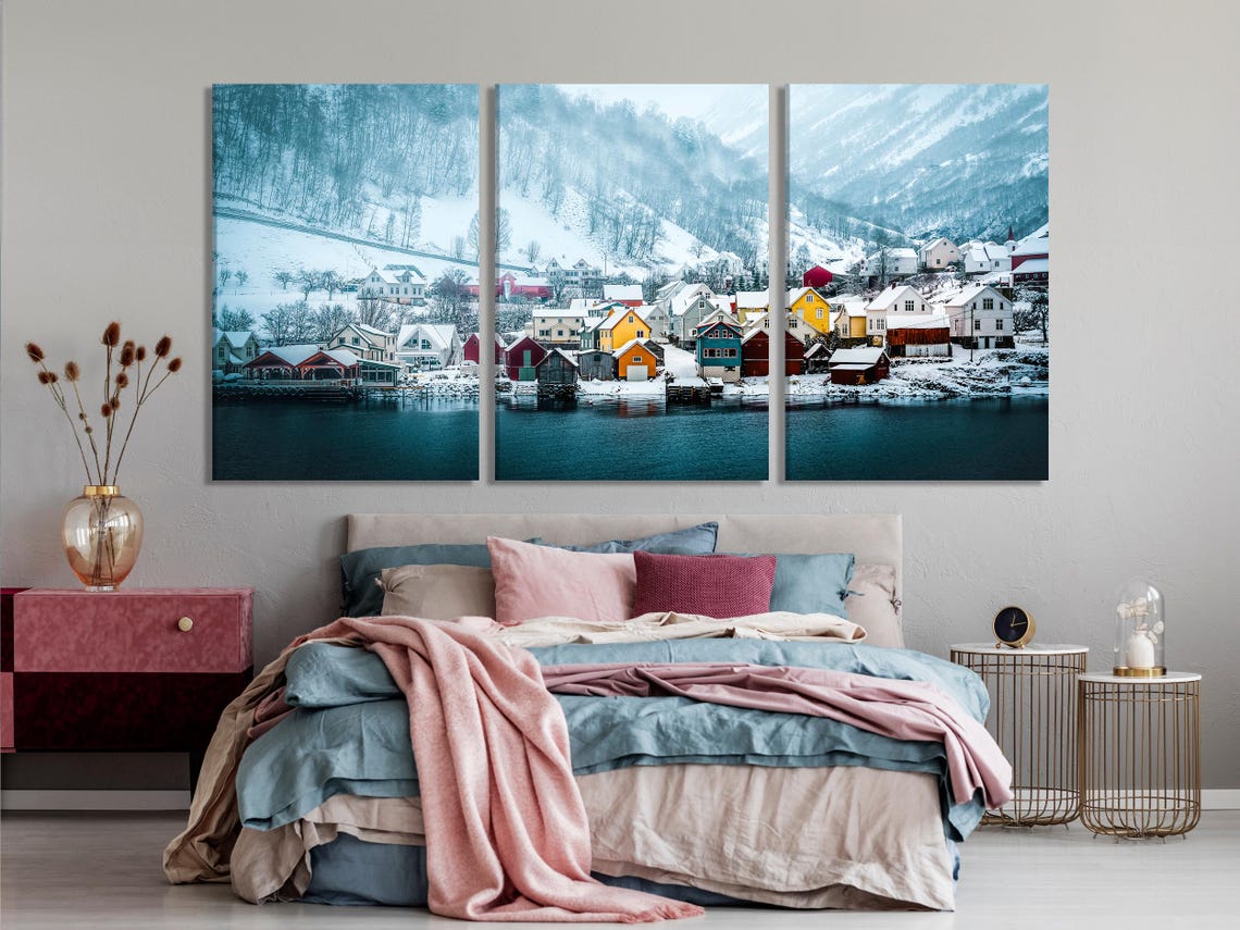 Winter village artwork displayed on a wall above a dining table