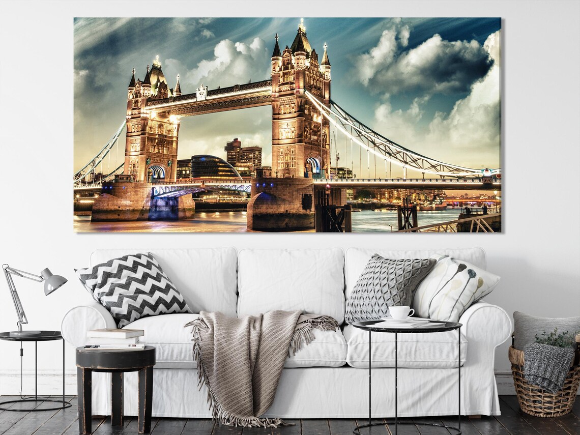 Triptych night cityscape artwork above a green sofa in a bright living room