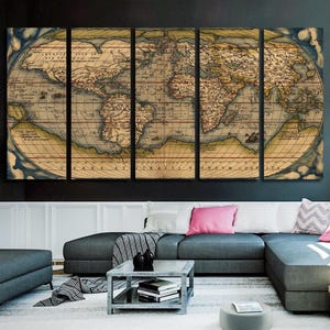 K&ouml;nnte beinhalten: Ein Vintage-Weltkarten-Canvas-Druck in f&uuml;nf Teilen, mit einer Karte im antiken Stil mit verblassten Farben und filigranen Details. Die Karte ist in einem dunklen Holzrahmen gerahmt und h&auml;ngt an einer schwarzen Wand.