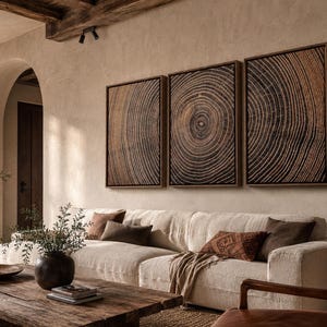 A set of three rectangular wall art pieces featuring a detailed dark brown and black wood grain cross-section pattern, each framed in a thin wooden border, displayed horizontally in a row on a textured beige wall.