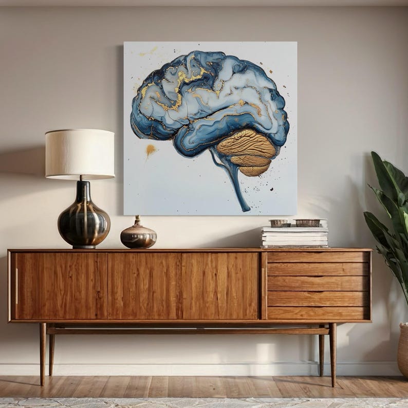 May include: A blue and gold abstract painting of a brain on a white background. The brain is painted in a swirling, fluid style, with gold accents. The painting is framed and hanging on a wall above a wooden cabinet.