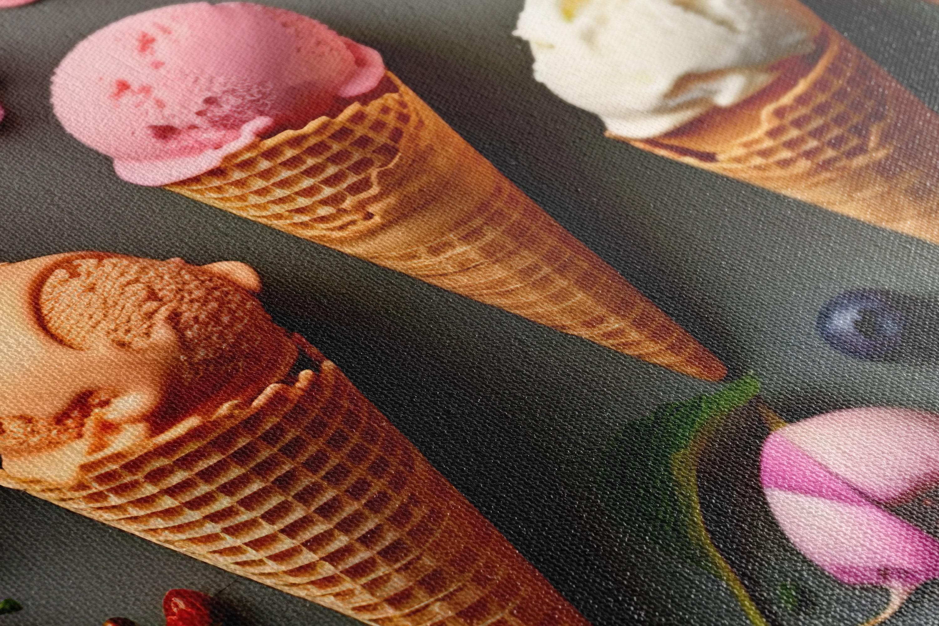 A colourful arrangement of ice-cream cones, scoops and berries sits on a dark grey background, surrounded by scattered flowers and mint leaves detail