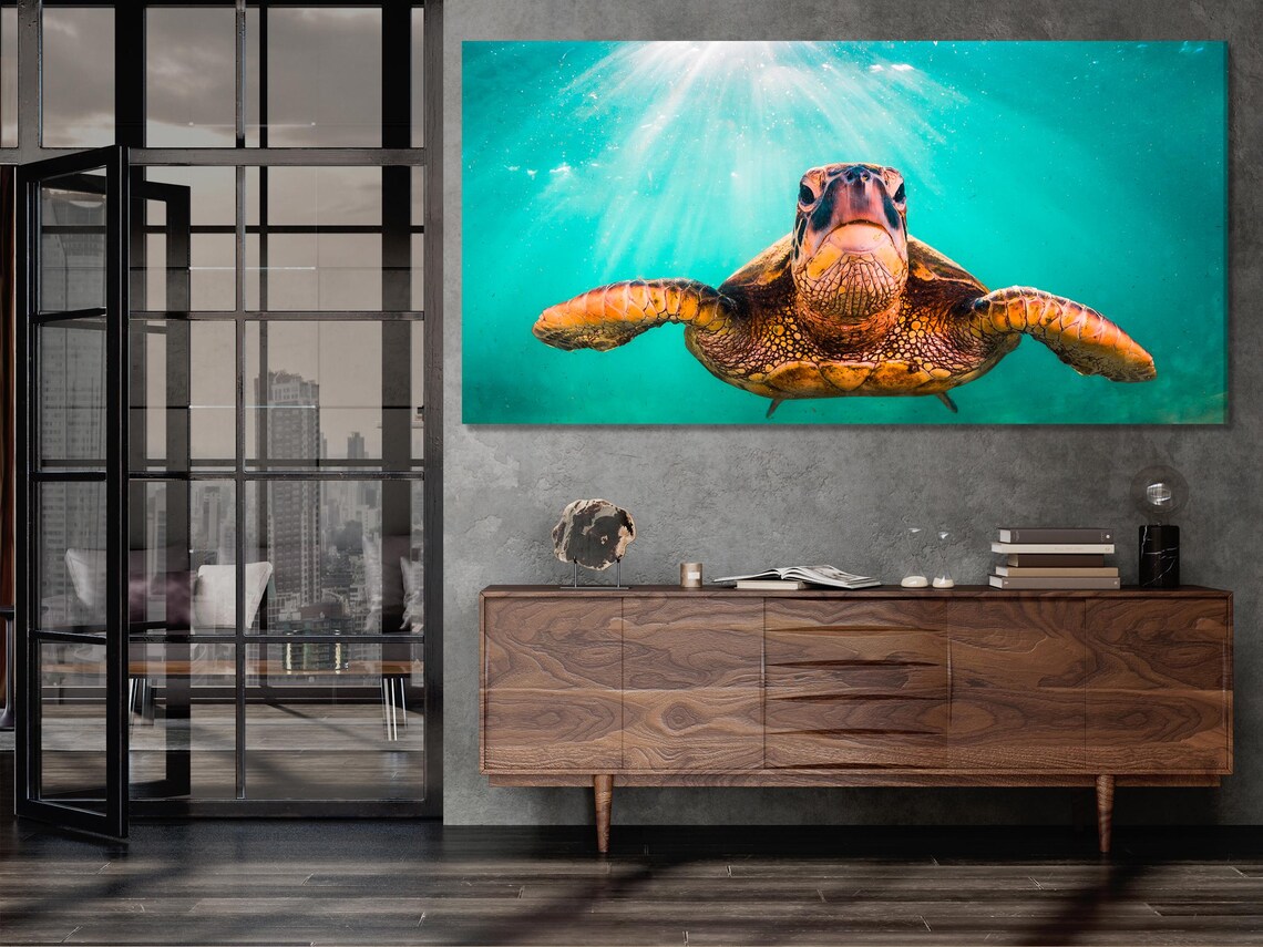 Underwater sea turtle swimming in turquoise water with diagonal sunrays detail view