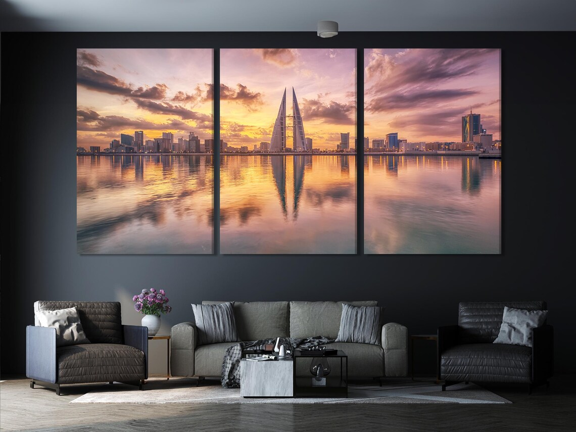 Sunset city skyline with a tall pointed tower and reflections on calm water detail view