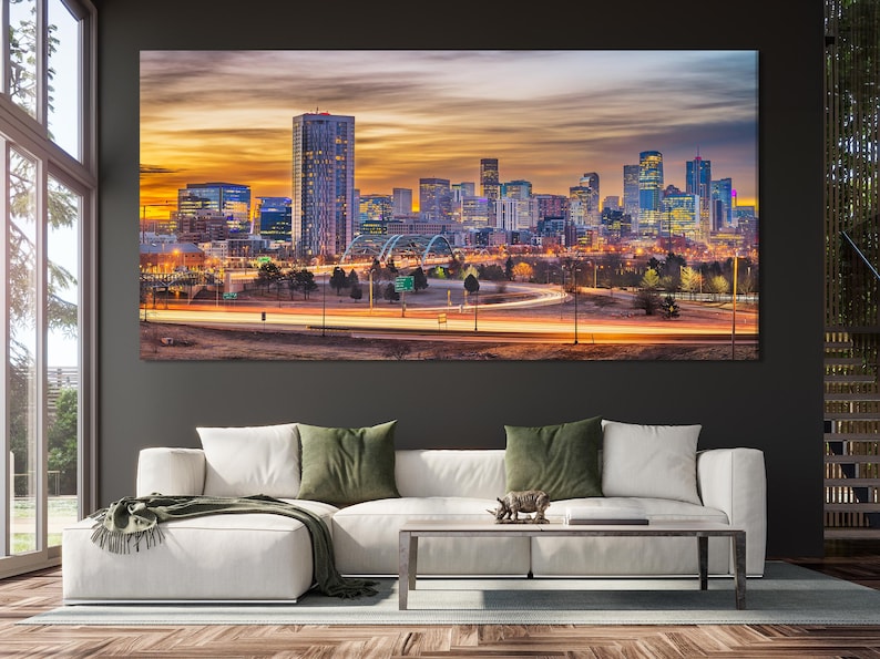 Dusk city skyline with tall buildings, glowing windows, a bridge, and sweeping traffic light trails