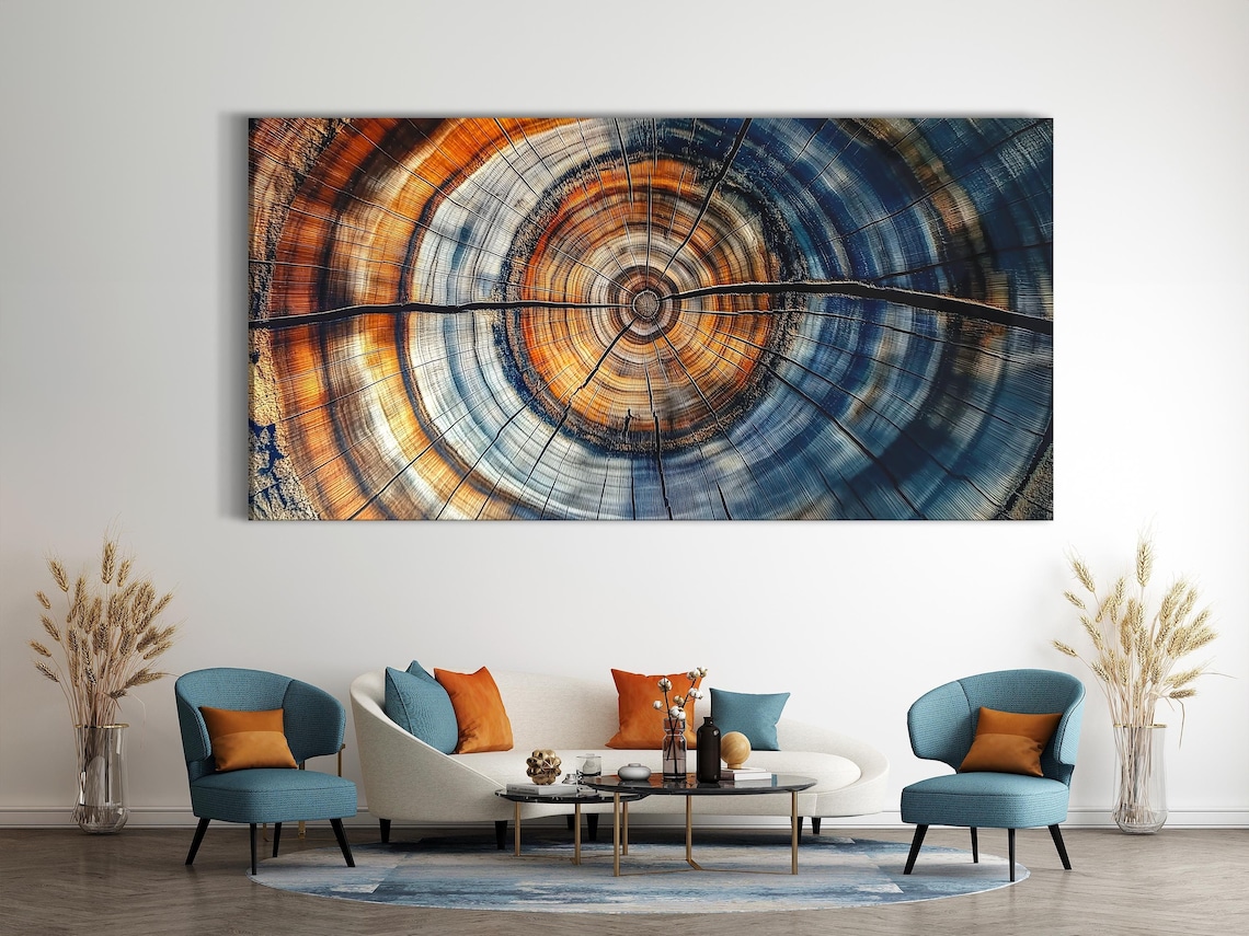 Dining table in a room with three blue and burnt orange abstract tree-ring panels on the wall