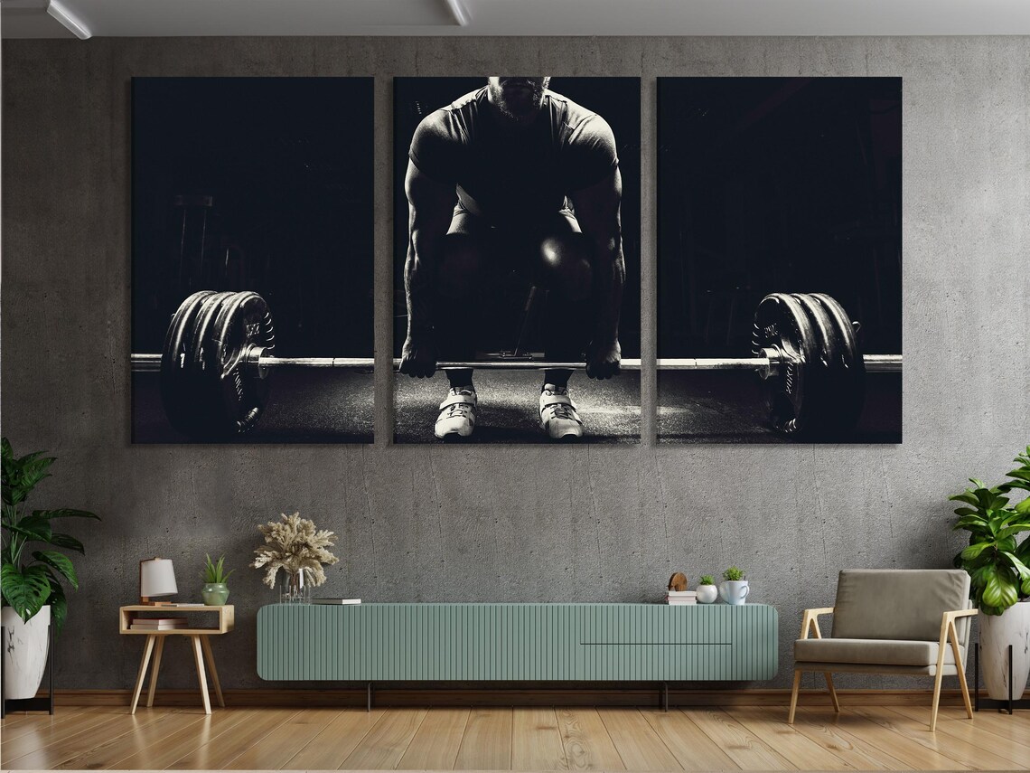 A living room scene with a large black and white weightlifting artwork above a sofa