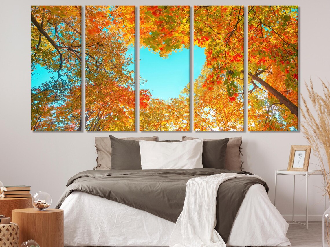 Autumn forest canopy with tree branches and dense fall leaves framing a bright blue sky detail view