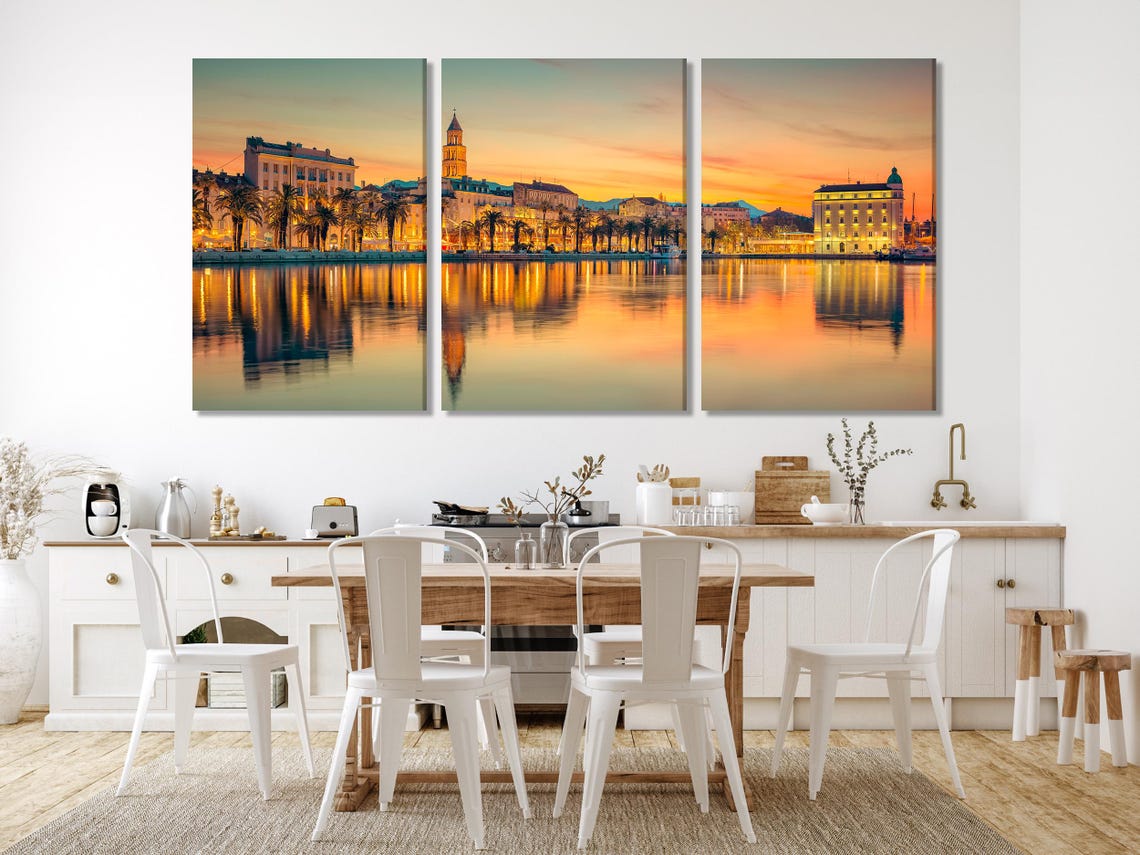 A sunlit waterfront cityscape at golden hour shows palm-lined buildings and a calm reflection across the water, with bright orange and teal tones