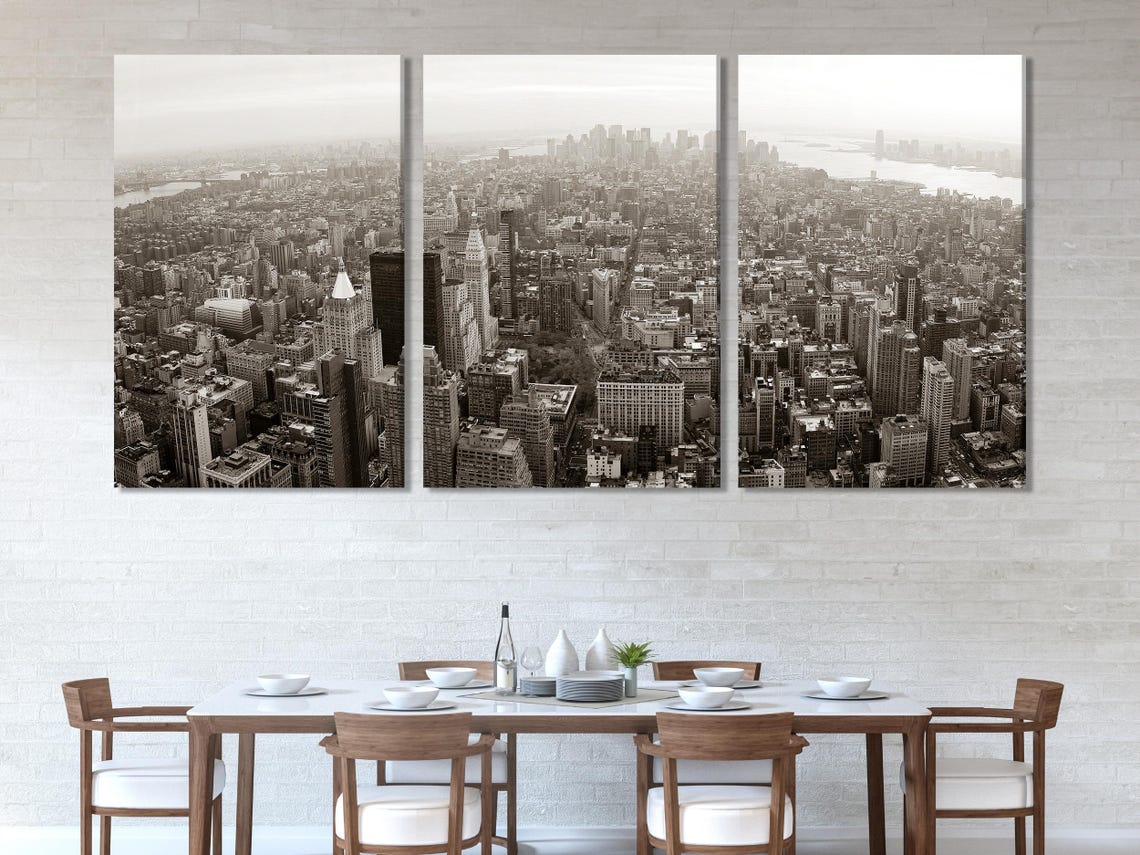 Room mockup with a monochrome city skyline artwork above a green sofa