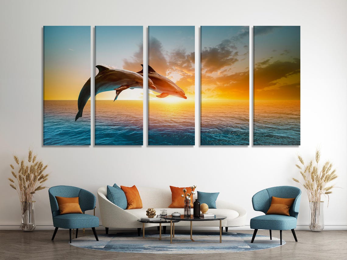 Two dolphins leaping over teal ocean waves under a golden sunset sky detail view