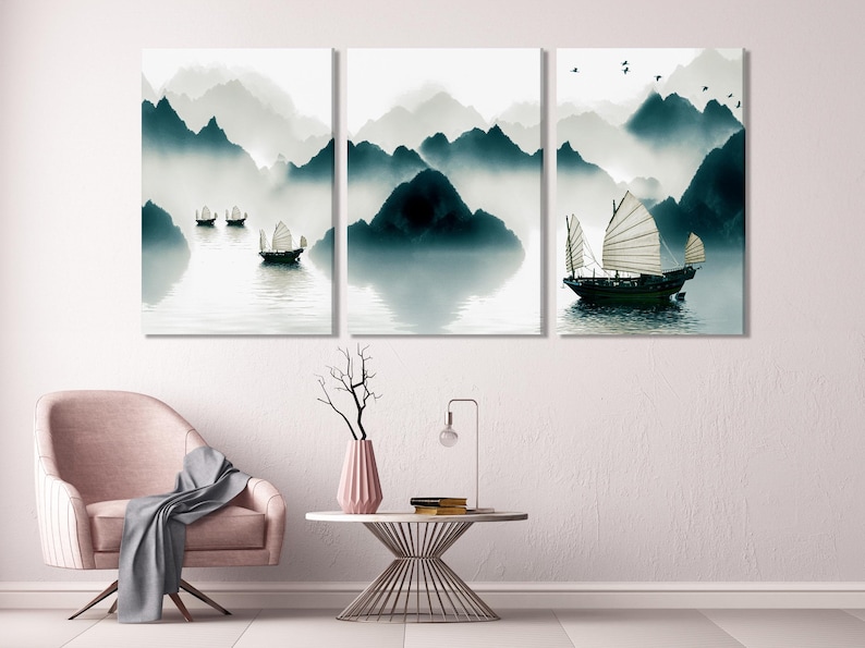 Misty mountain landscape in grey and teal tones with calm water reflections and small sailing boats