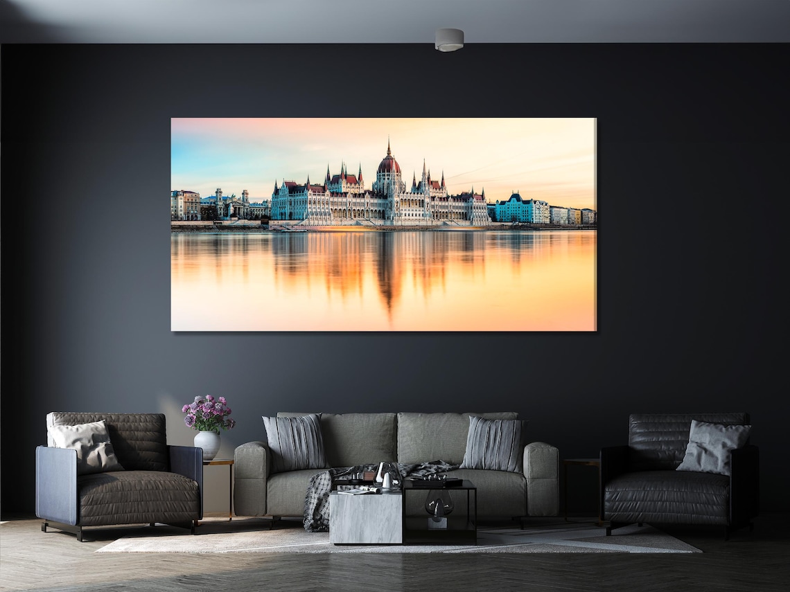 Living room with green sofa and five-panel sunset cityscape skyline artwork above