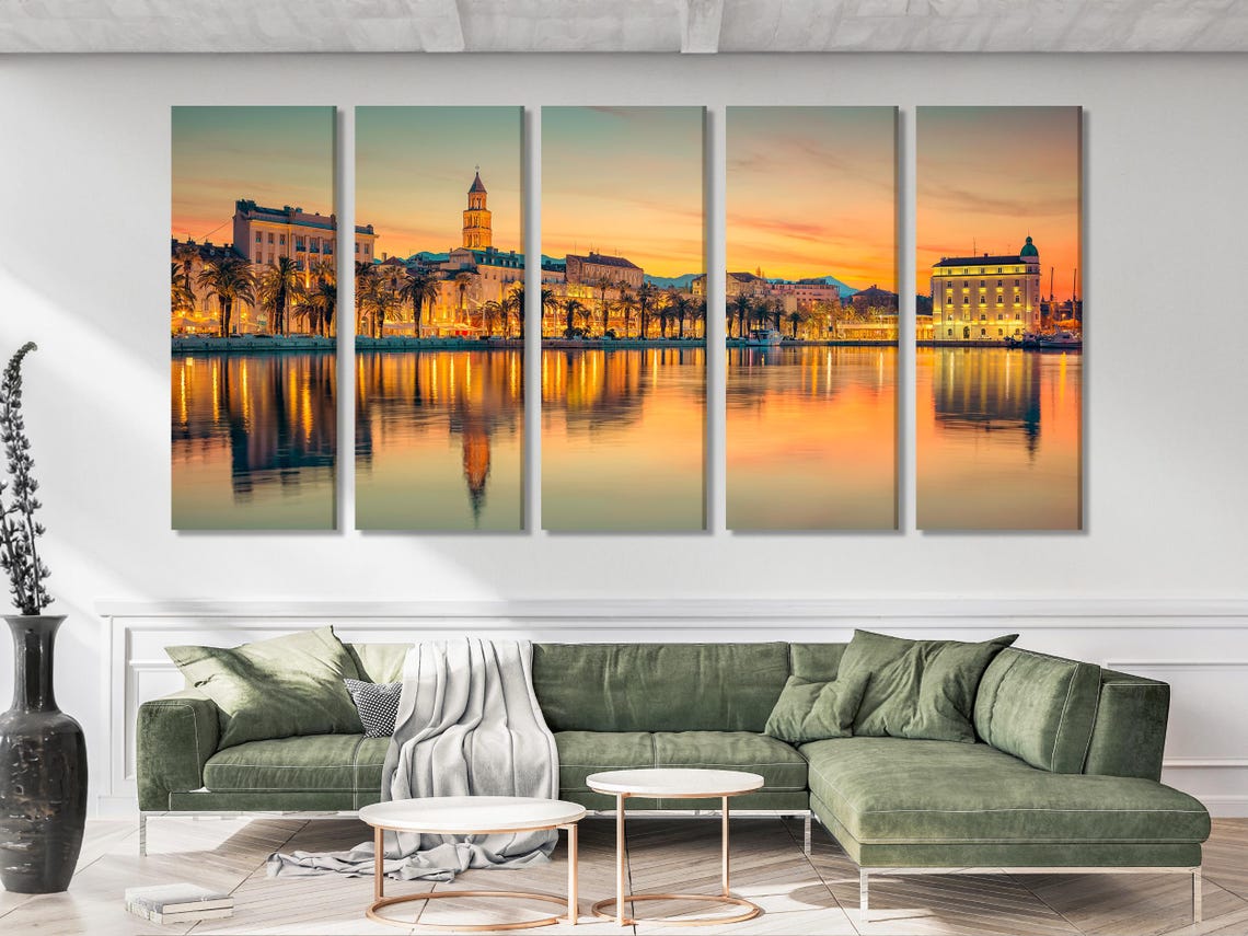 A sunlit waterfront cityscape at golden hour shows palm-lined buildings and a calm reflection across the water, with bright orange and teal tones
