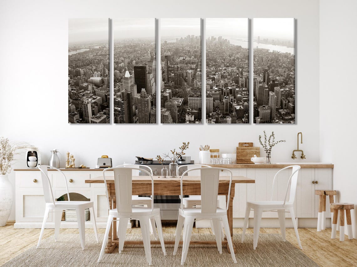Room mockup with a monochrome city skyline artwork above a green sofa