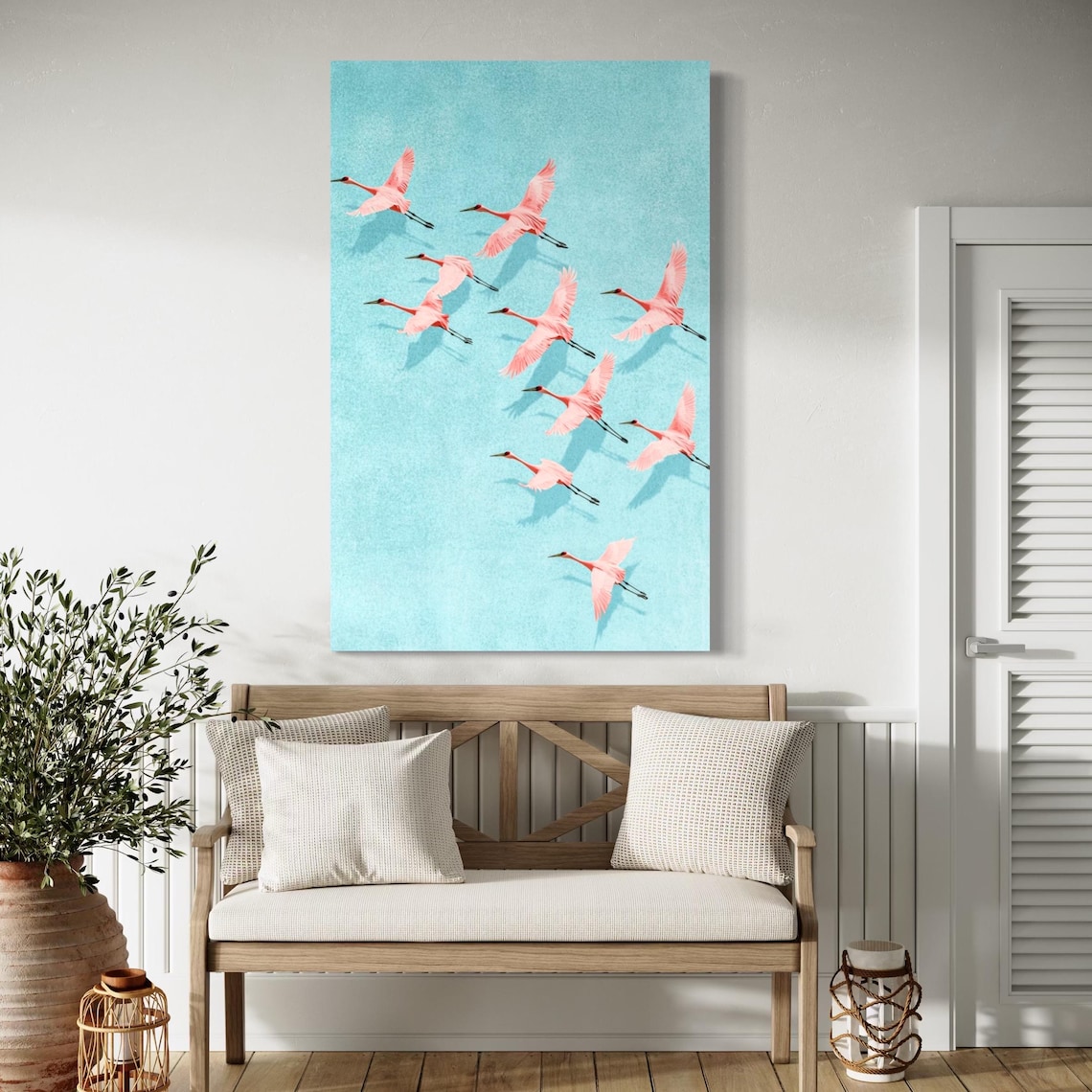 Pink cranes birds artwork shown above a white sofa in a bright living room