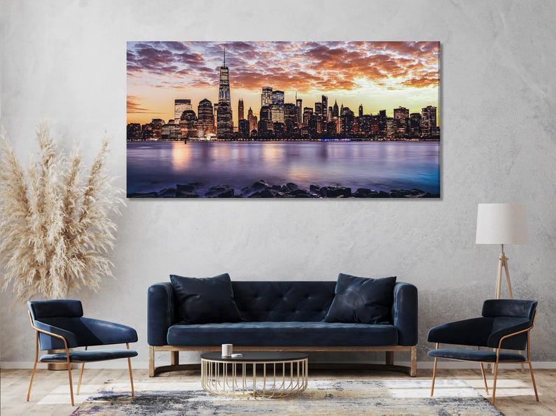 Sunset city skyline with skyscrapers, clouds, and a reflective water horizon