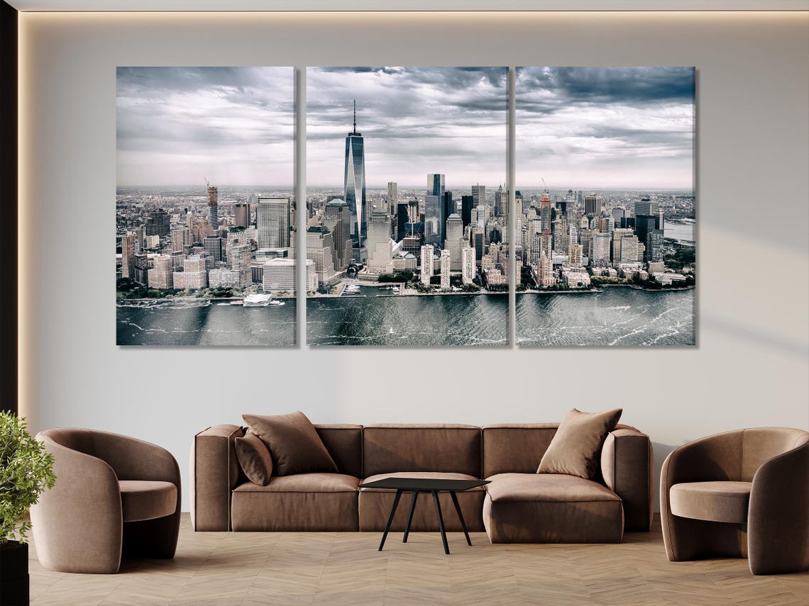 Grey city skyline artwork hung above a sofa in a bright living room mockup