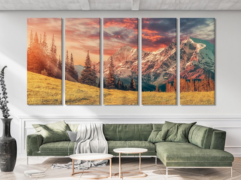 Mountain landscape artwork with a golden meadow, evergreen trees, snow-capped peaks and a sunset sky