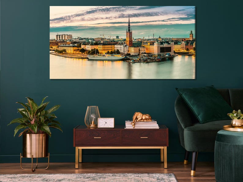 Sunset city skyline with tall tower spires and golden reflections on calm water