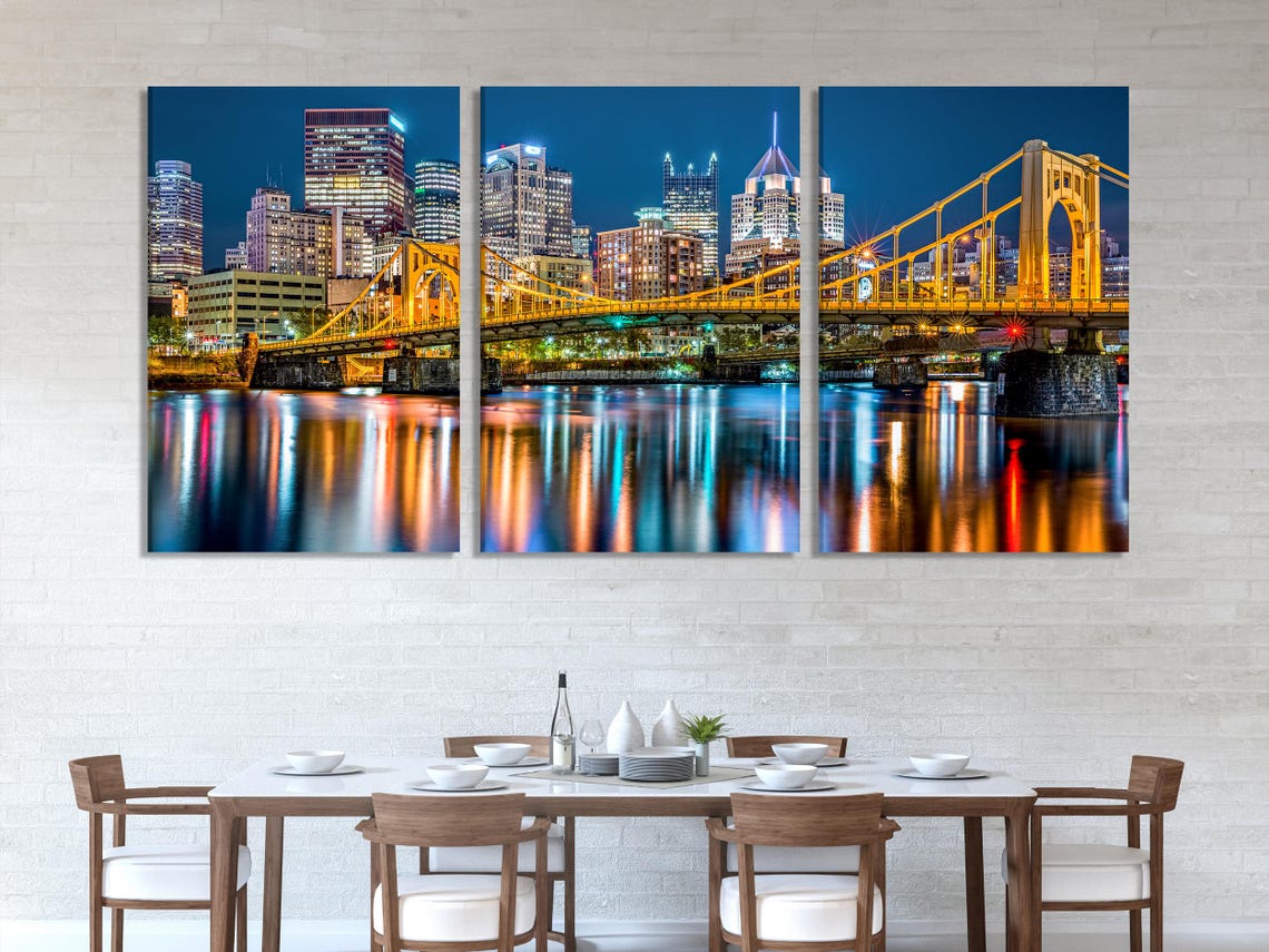 Room mockup with a wide night city skyline artwork featuring a lit bridge and river reflections
